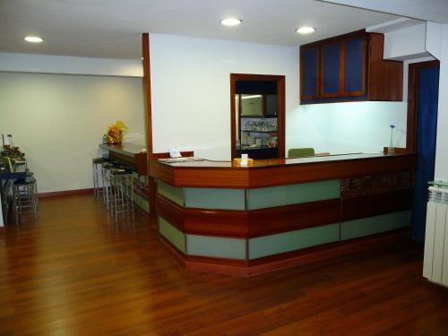 a kitchen with a large counter top and wooden floors at Hostal Liebana in Santander