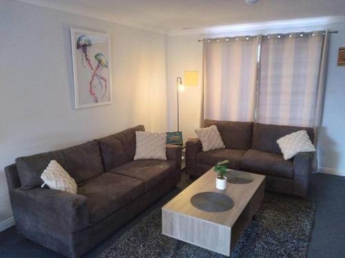 a living room with a couch and a coffee table at Cosy 2 bedroom Unit in a secure gated complex in Kalgoorlie