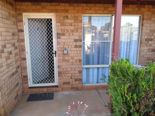 a front door of a house with a gate at Cosy 2 bedroom Unit in a secure gated complex in Kalgoorlie