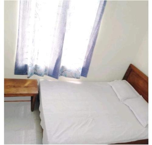 a small bedroom with a bed and a window at Hotel Bonolota international in Rājshāhi