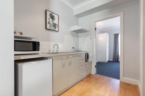 a white kitchen with a sink and a microwave at St Francis Winery in Old Reynella