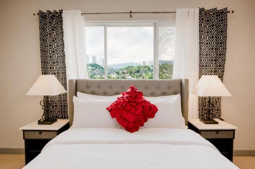 Un dormitorio con una cama con una flor roja. en Sta Barbara Residence Hotel, en Cebú