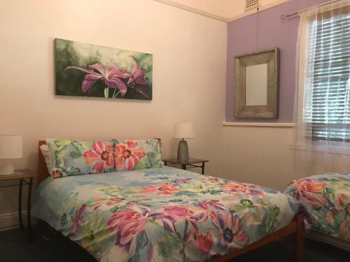 a bedroom with a bed and a painting on the wall at Flying Fox Backpackers in Katoomba