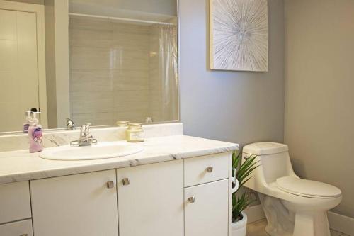 a bathroom with a white sink and a toilet at Next to Olympic View golf course 2 bedroom private suite in Victoria
