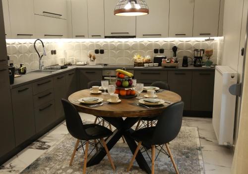 a kitchen with a table with a bowl of fruit on it at LA Larissa Luxury Apartments Kreousa in Larisa