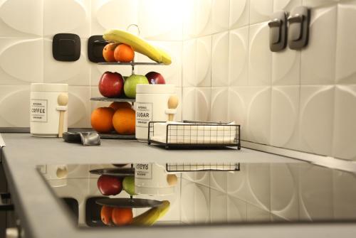 a kitchen counter with fruits and vegetables on a shelf at LA Larissa Luxury Apartments Kreousa in Larisa
