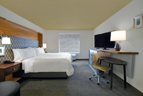 a hotel room with a bed and a desk and a chair at Holiday Inn Grand Rapids North - Walker, an IHG Hotel in Walker
