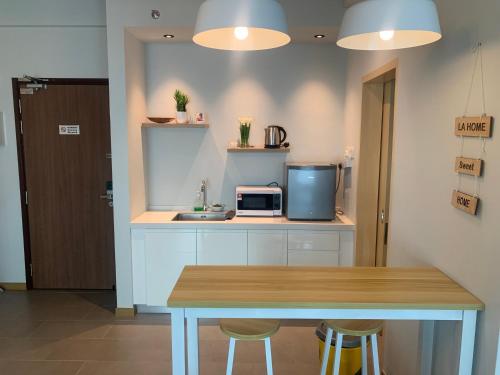 a small kitchen with a table and a microwave at Imperium residence (LA HOMES) in Kuantan