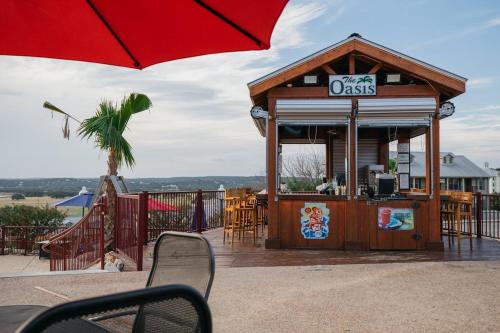 a small establishment with a red umbrella on a patio at Holiday Inn Club Vacations Hill Country Resort at Canyon Lake in Canyon Lake