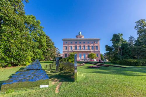 a large building in the middle of a grass field at Boutique Apartments in Lugano
