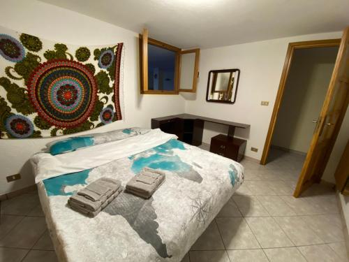 Appartamento Le Soleil Torgnon في تورنيون: غرفة نوم عليها سرير وعليها شنطتين