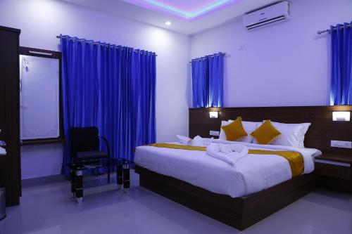 une chambre avec un grand lit avec des rideaux bleus dans l'établissement AP Residency, à Wayanad