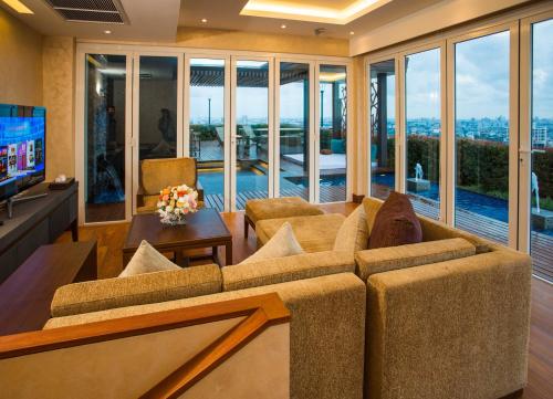a living room with a couch and a tv at The Grand Fourwings Convention Hotel Bangkok in Bangkok