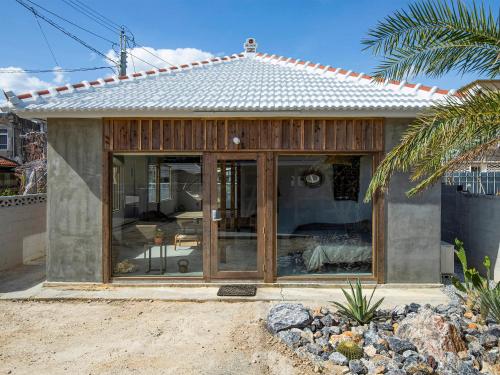 a house with sliding glass doors in a yard at irregular INN Nakijin in Nakijin