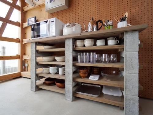 a kitchen with wooden shelves with utensils at irregular INN Nakijin in Nakijin