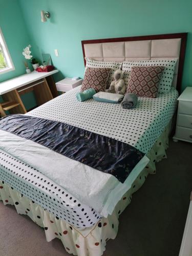 a bedroom with a bed with a teddy bear on it at Wendy's Holiday Home in Auckland