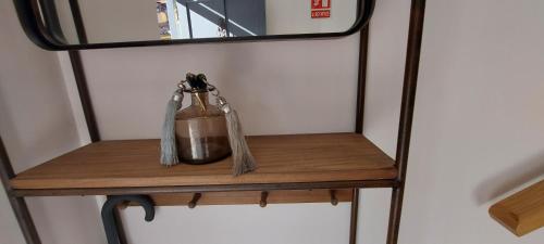 a small wooden shelf with a bottle on it at LA CASITA in Hervás