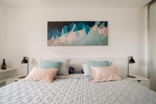 里約熱內盧的住宿－LEBLON - TOP LOCATION - Serviced Apartment，一间卧室配有一张大床,配有粉色和蓝色的枕头