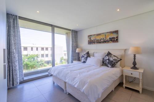 a bedroom with a bed and a large window at Unit 215 Oceandune - Stunning & Modern Apartment in Sibaya