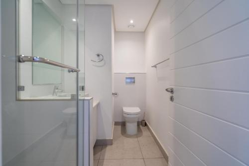 a bathroom with a toilet and a glass shower at Unit 215 Oceandune - Stunning & Modern Apartment in Sibaya