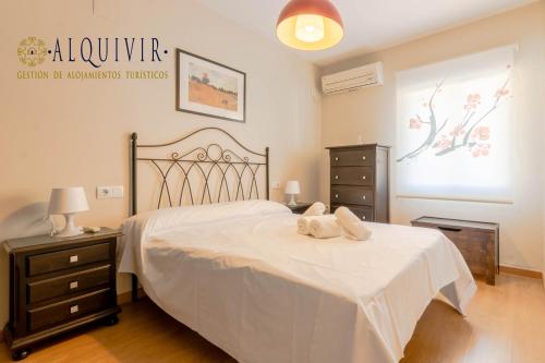 1 dormitorio con 1 cama grande con colcha blanca en Apartamento CONDE DE PRIEGO en Córdoba