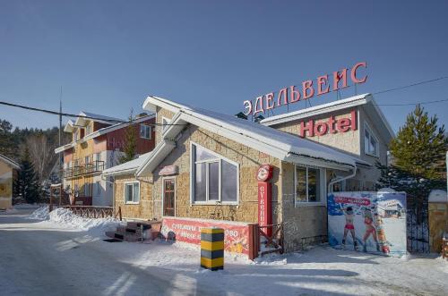 un hotel con un cartello sopra nella neve di Edelweiss Hotel ad Abzakovo