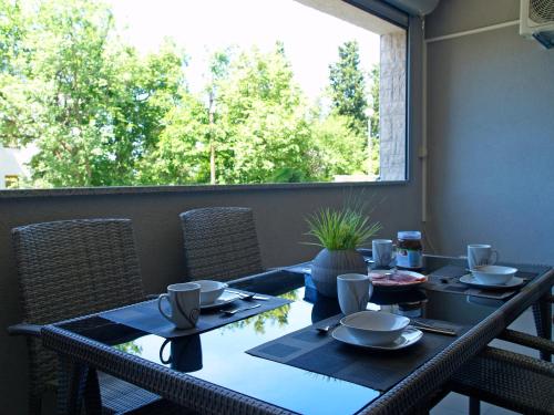 a dining table with chairs and a large window at Apartment Summertime in Crikvenica