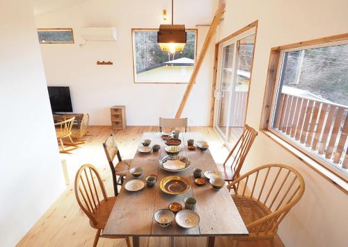 a dining room with a wooden table and chairs at とけとけ山荘 in Fujikawaguchiko