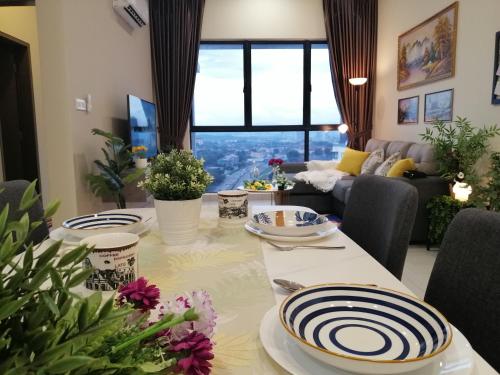 a living room with a table with plates on it at Astetica Residences @ Seri Kembangan in Seri Kembangan