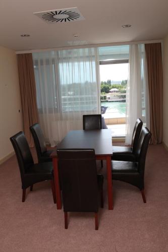 a dining room with a table and chairs and a window at Arena Hotel Kur in Mingachevir