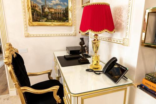 a desk with a lamp and a phone on it at Royal Palace Luxury Hotel and SPA in Khmelʼnytsʼkyy