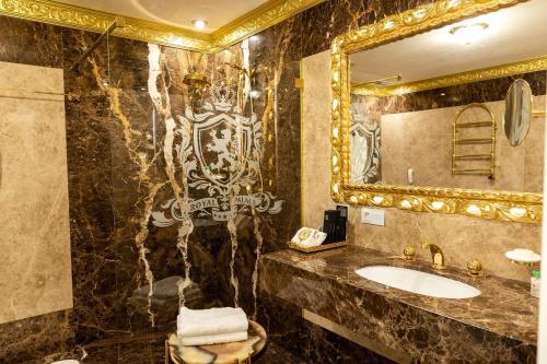 a bathroom with a sink and a mirror at Royal Palace Luxury Hotel and SPA in Khmelʼnytsʼkyy