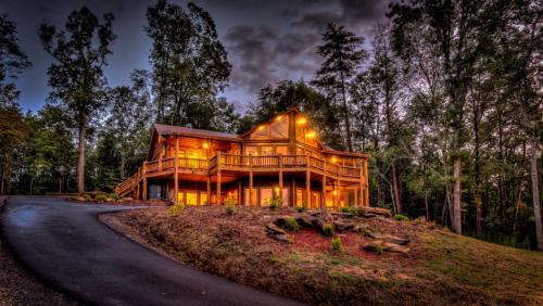 a large wooden house in the woods at night at Serenity Peak in Blue Ridge