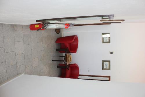 a room with a red chair and a fire hydrant at Guesthouse San Antonio in Ploče