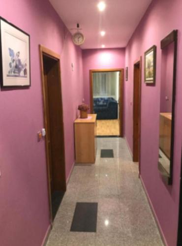 a hallway with pink walls and a hallway with doors at Guesthouse San Antonio in Ploče