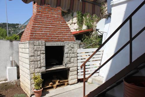 an outdoor pizza oven with a brick chimney at Guesthouse San Antonio in Ploče