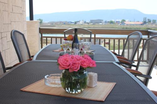 uma mesa com um vaso cheio de rosas cor-de-rosa em Guesthouse San Antonio em Ploče