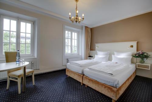 Un dormitorio con una cama grande y una mesa. en Hotel Fürst Bismarck, en Hamburgo