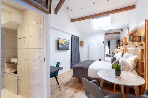 a bedroom with a bed and a table and chairs at Les studios de la faisanderie in Chantilly