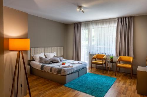Schlafzimmer mit einem Bett mit blauem Teppich in der Unterkunft Sunny Hills Ski&Wellness in Pamporowo