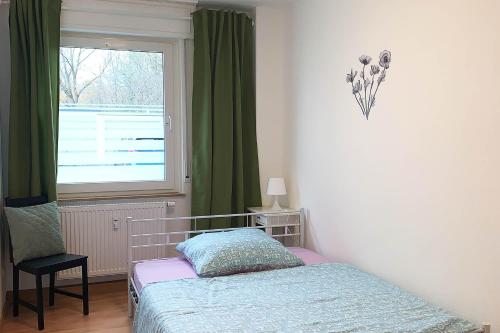a bedroom with a bed and a window with green curtains at 3 room holiday flat in Hemer