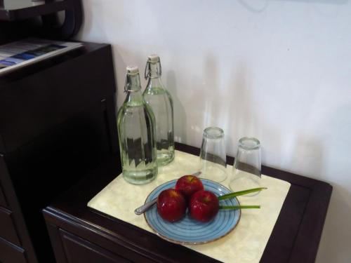 a table with a plate of tomatoes and two bottles at The Sunrise Huraa in Huraa