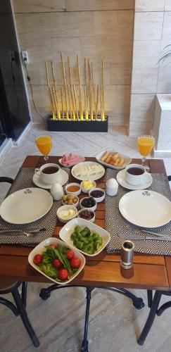 een houten tafel met borden met eten erop bij The Place Suit & Apartments in Istanbul