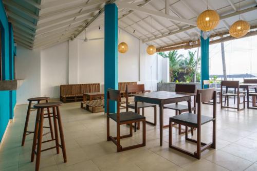 een eetkamer met tafels, stoelen en lampen bij Shangrela Beach Resort by ARK in Ambalangoda