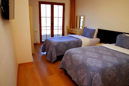 a hotel room with two beds and a window at Miletus Otel Şile in Sile