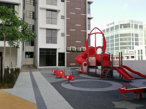 a playground with a red slide in front of a building at Astetica Residences @ Seri Kembangan in Seri Kembangan