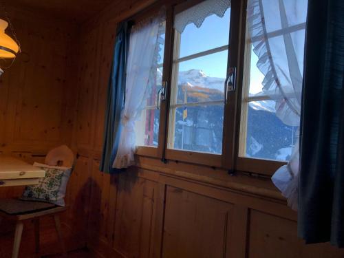 a window in a room with a view of a mountain at Sonniges Chalet Arosa für 6 Pers alleinstehend mit traumhaftem Bergpanorama in Langwies