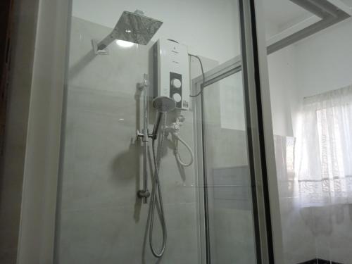 a shower in a bathroom with a glass door at Alex Home Stay in Kandy