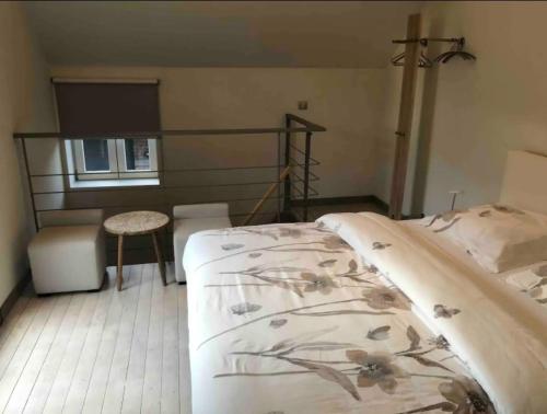 een slaapkamer met een bed, een tafel en een raam bij 'T Achterhuys in Oostende