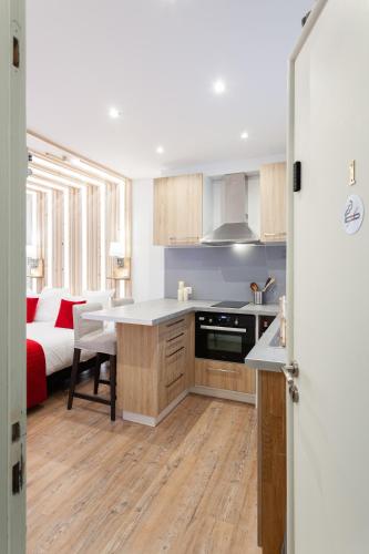 a kitchen with a table and a bed in a room at Les studios de la faisanderie in Chantilly